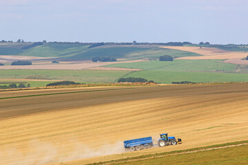 Tractor working Fields of the Pewsey Vale, Wiltshire at harvest	