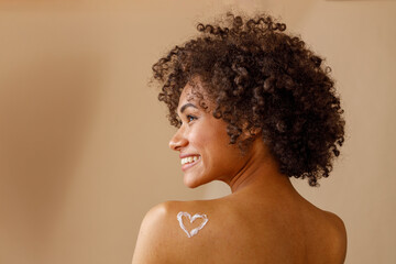 Fototapeta Beautiful lady with curly hairstyle posing against beige wall obraz