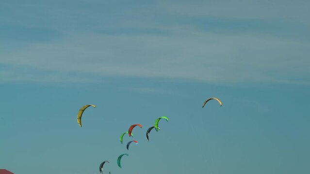 Cluster of kiter parachutes against the blue sky hanging in the air