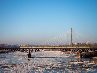 Warsaw, Poland - December 2021: The Cross-city Bridge, Railway bridge over the Vistula River, Train running on the bridge