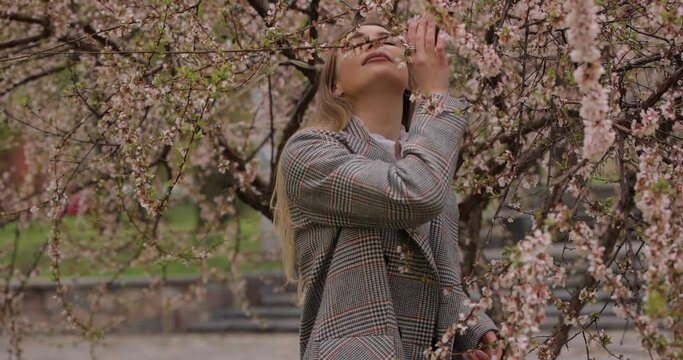 Woman sniff the aroma of beautiful blossom tree in the park