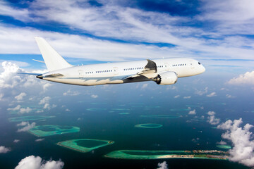 The passenger plane flies high above the Maldive atolls.