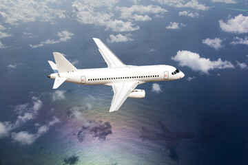 Passenger plane flies over the ocean. View of the plane from above.