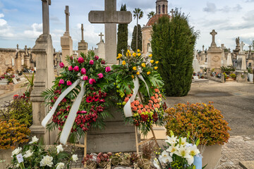 Kränze und Gebinde mit Schleifen auf einem
Friedhof  auf  Spaniens Insel Palma de Mallorca