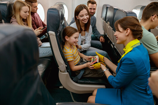 Stewardess Giving Cookies To Little Girl In Airplane