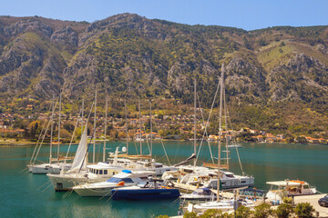 Fototapeta na wymiar Mediterranean landscape. Montenegro, Bay of Kotor. Sailboats and yachts in port of Kotor city against Vrmac mountain on sunny spring day