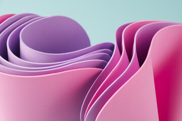 Dynamic motion abstract elements with pink and periwinkle sheets on a sunny teal background....