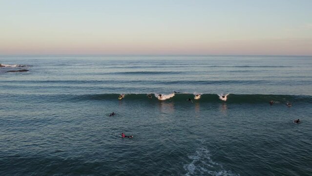 Drone footage of surfers at golden hour