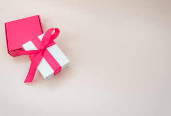 Gift pink and white boxes on beige background with space for text. Concept of mother's day, gifts, discounts and sales