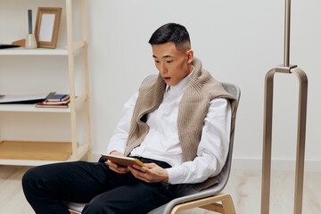 Asian man sweater on shoulders tablet internet technologies