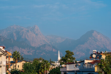 landscape with distant blue mountains behind city rooftops, Kemer, Antalya, Turkey