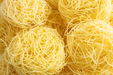 Texture of stacked vermicelli nests, still raw. Delicious thin egg paste on white background