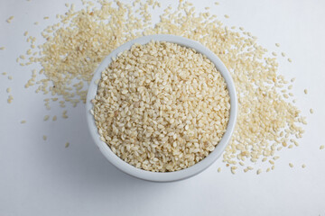 Top view of white sesame seeds (Sesamum indicum), still raw inside small ceramic bowl