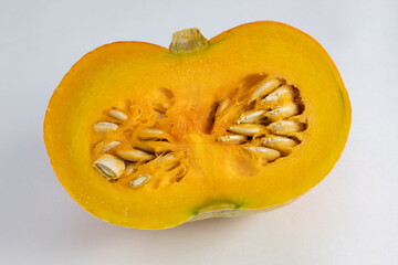 Half pumpkin, raw and fresh, with exposed seed and rind, on white background