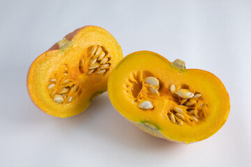 Ripe and fresh pumpkin, cut in half, with skin and seeds exposed. on white background