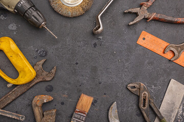 Labour day background concept - different construction tools on dark stone background with copy space