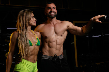 Fototapeta na wymiar Couple with muscular body at the gym