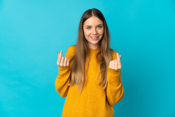 Young Lithuanian woman isolated on blue background making money gesture