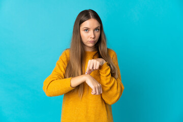 Young Lithuanian woman isolated on blue background making the gesture of being late