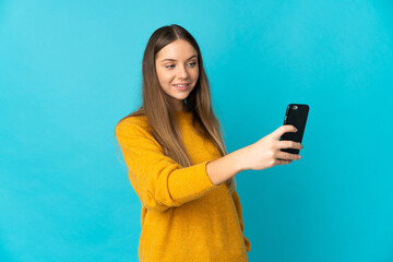 Naklejka premium Young Lithuanian woman isolated on blue background making a selfie