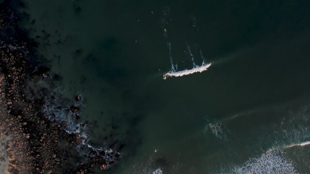 Drone footage of surfers at golden hour