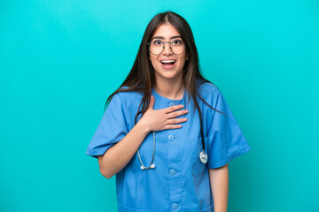 Young nurse caucasian woman isolated on blue background surprised and shocked while looking right