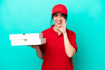 Pizza delivery woman with work uniform picking up pizza boxes isolated on blue background shouting...
