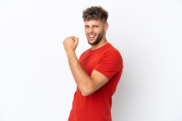 Young caucasian handsome man isolated on white background celebrating a victory