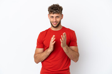 Young caucasian handsome man isolated on white background applauding after presentation in a...