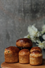 Delicious Easter cakes on a wooden table with flowers in the background. place for text. selective focus