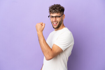 Delivery caucasian man isolated on purple background celebrating a victory