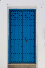 Beautiful, blue door with black studs and handle in Frigiliana. Malaga, Andalusia, Spain