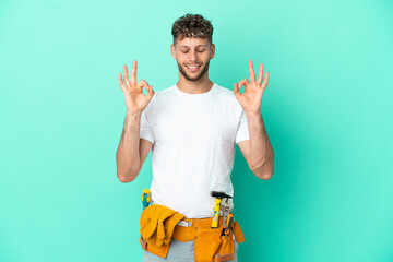 Young electrician blonde man isolated on green background in zen pose