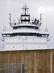 Fototapeta premium Fähre hinter Hafenmauer in Cuxhaven