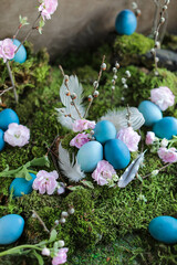 Beautiful Easter blue eggs on green fresh moss. Easter decor with natural items and colored eggs. Floral natural composition.
