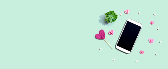 Smartphone with hearts and a succulent - flat lay - obrazy, fototapety, plakaty