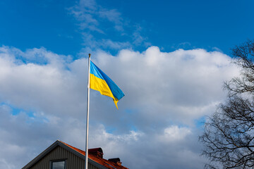 The flag of Ukraine flying proudly by a house.