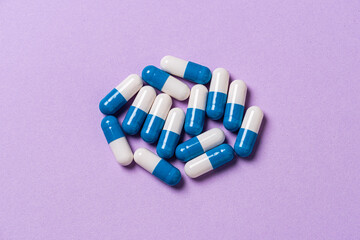 White and blue medicine pills on a table.