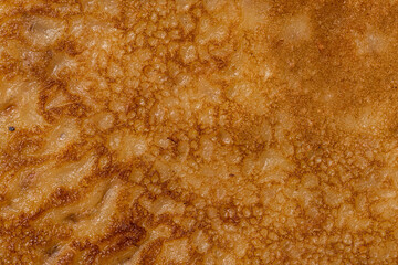 Details of freshly made pancakes on a plate.