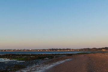 Beautiful color of sky in evening at beach before sunset. Landscape of town next to coast line, mountain, water, land, sand. Freshness and mindful. Nature scenery
