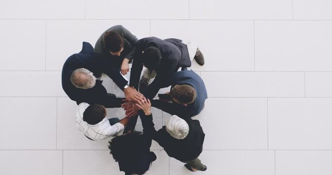 Motivation is what gets us ahead. 4k footage of a group of businesspeople joining their hands together in a huddle.