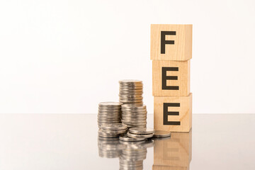 FEE - text on wooden cubes on white background with coins