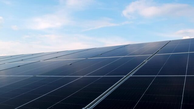 Closeup of surface of blue photovoltaic solar panels mounted on building roof for producing clean ecological electricity. Production of renewable energy concept.
