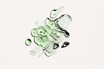Liquid green gel cosmetic smudge texture. Transparent Gel drops on light green background. Serum...