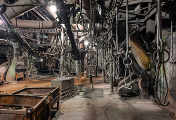 Interior of an old bankrupt factory. Stopped overhead conveyor with hooks for fastening parts