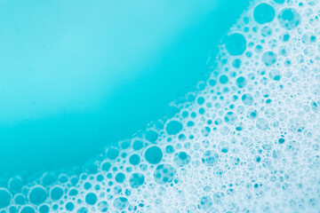 Blue water with white foam bubbles.Foam Water Soap Suds.foam bubbles. Texture Foam Close-up. blue soap bubbles background. - obrazy, fototapety, plakaty