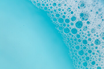 Blue water with white foam bubbles.Foam Water Soap Suds.Texture Foam Close-up. blue soap bubbles background. - obrazy, fototapety, plakaty