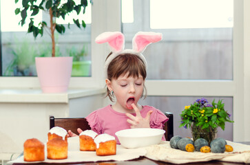 The girl decorates Easter cakes.  Easter preparations.