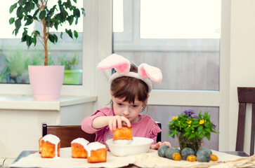 The girl decorates Easter cakes.  Easter preparations.