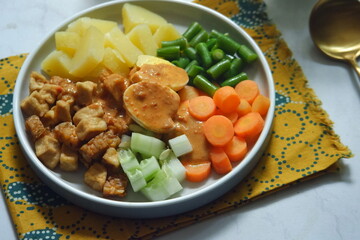 a plate of vegetable salad with peanut sauce named gado-gado in bahasa 